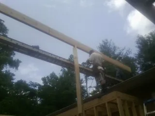 Carpenter setting a ridge beam over a new addition frame — Ice Dam Removal by Roofing Brothers in Hegins