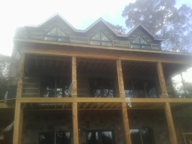 Dormers and porch framing on a large log home under construction — Roof Coating work by our crew in Hegins