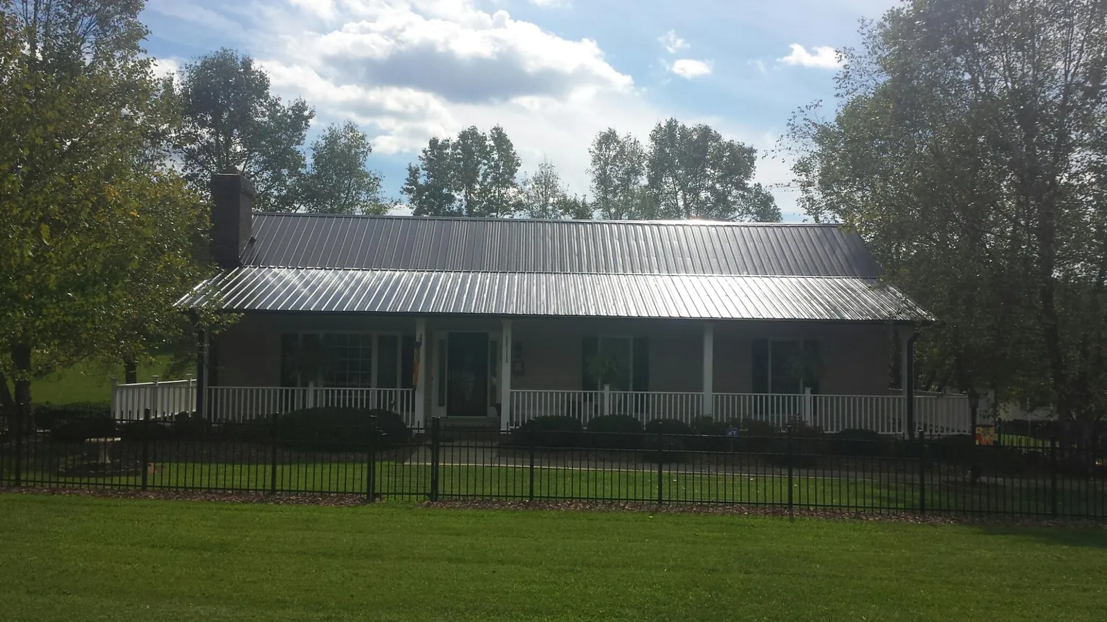 Gray metal roof on a brick ranch with a full width front porch — Gutter Guard Installation work by our crew in Hegins
