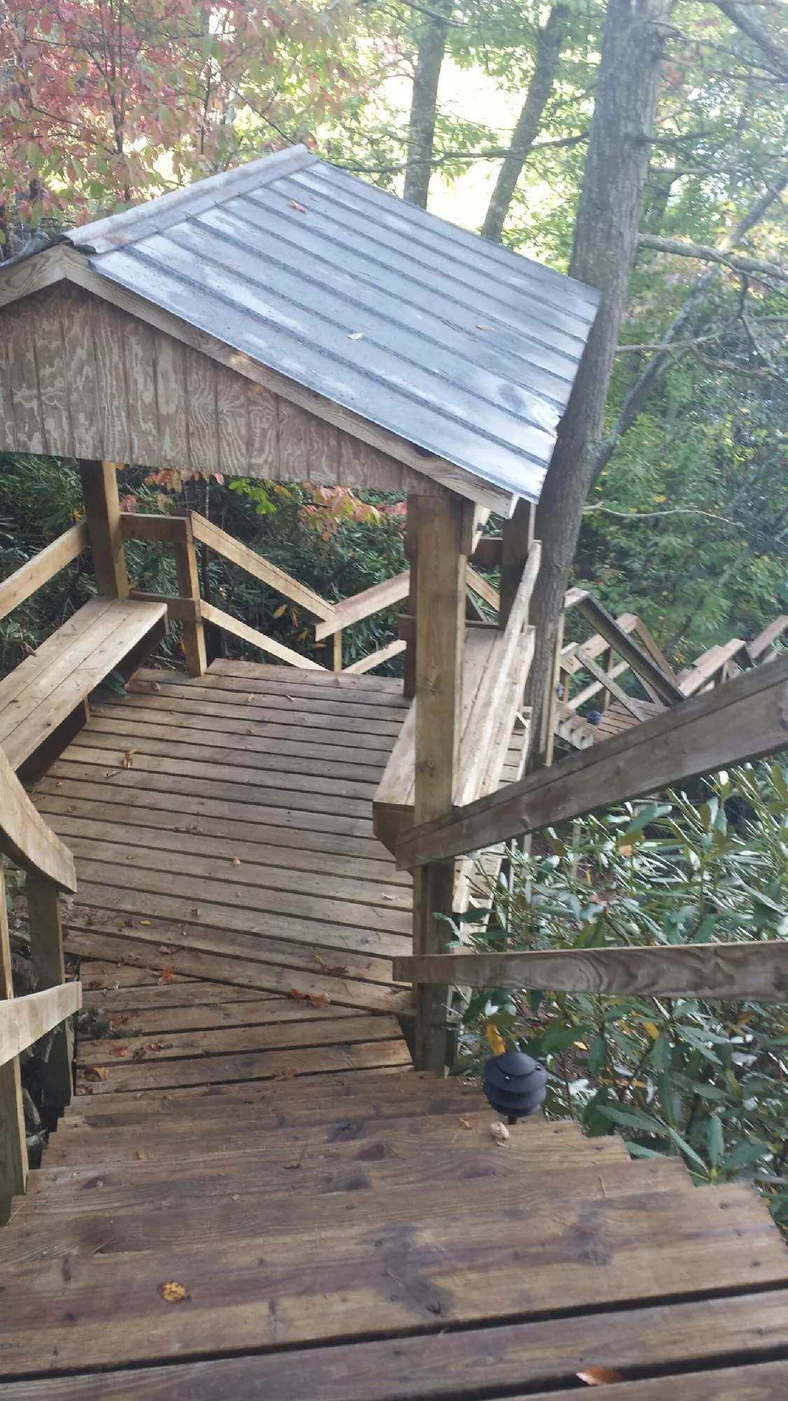 Metal roofed shelter over wooden steps on a wooded walkway — Skylight Repair & Installation work by our crew in Hegins